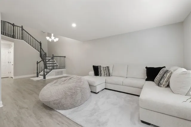 a bedroom with a bed couch and wooden floor