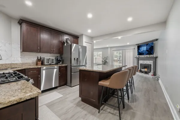 a kitchen with a table chairs refrigerator and cabinets