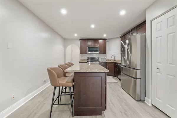 a kitchen with refrigerator and chairs