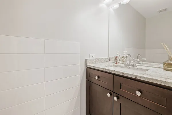 a bathroom with a granite countertop sink and a mirror