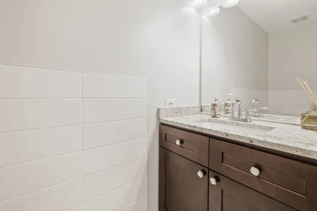a bathroom with a granite countertop sink and a mirror