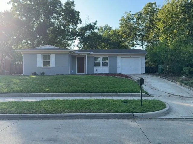 a front view of a house with a garden and plants