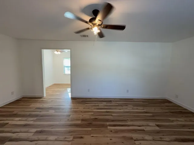 wooden floor in an empty room with a window