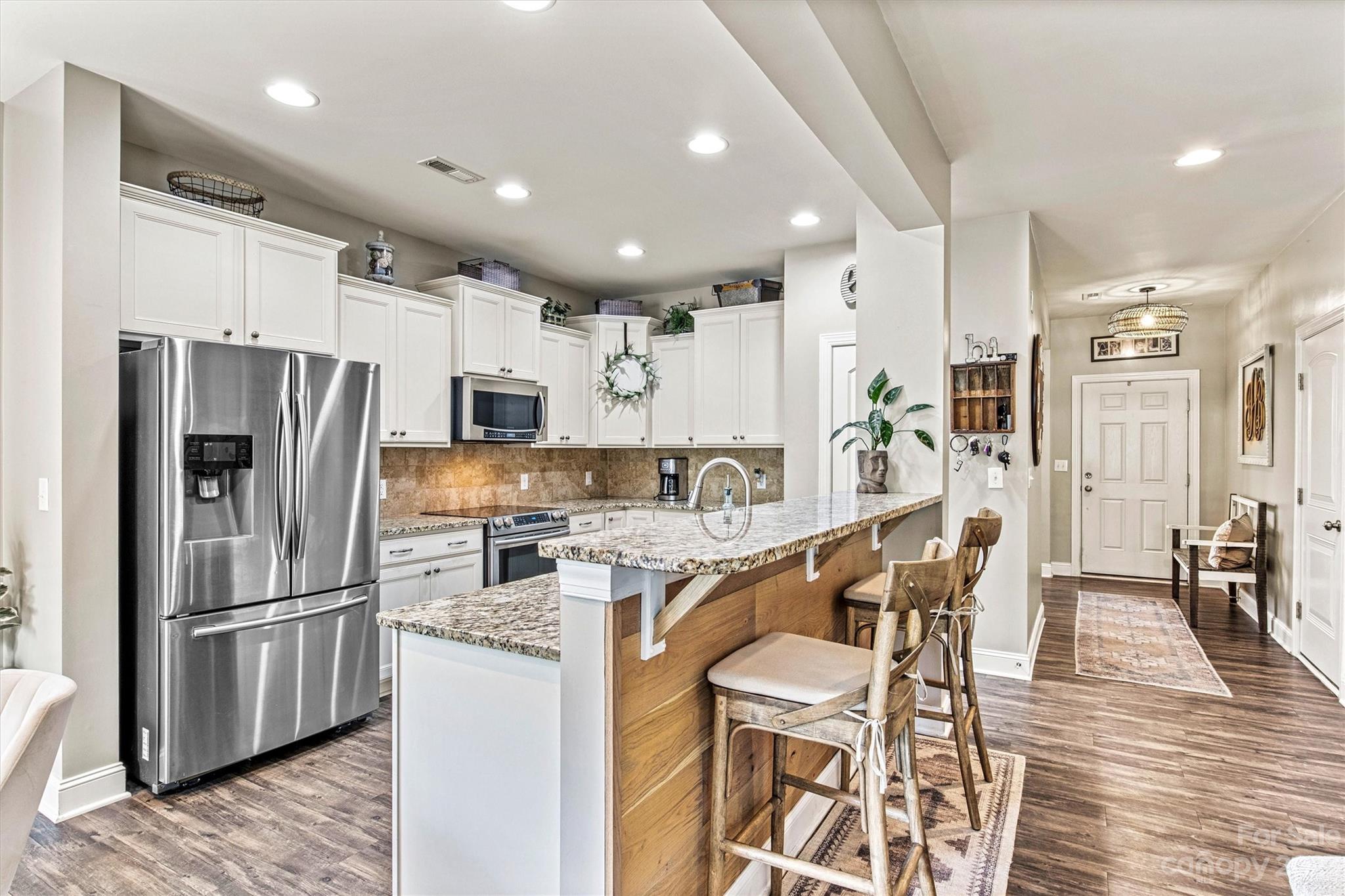 6054 Durango Way Denver, NC 28037 - Photo 7 of 38 a kitchen with stainless steel appliances granite countertop a refrigerator a stove a sink a dining table and chairs