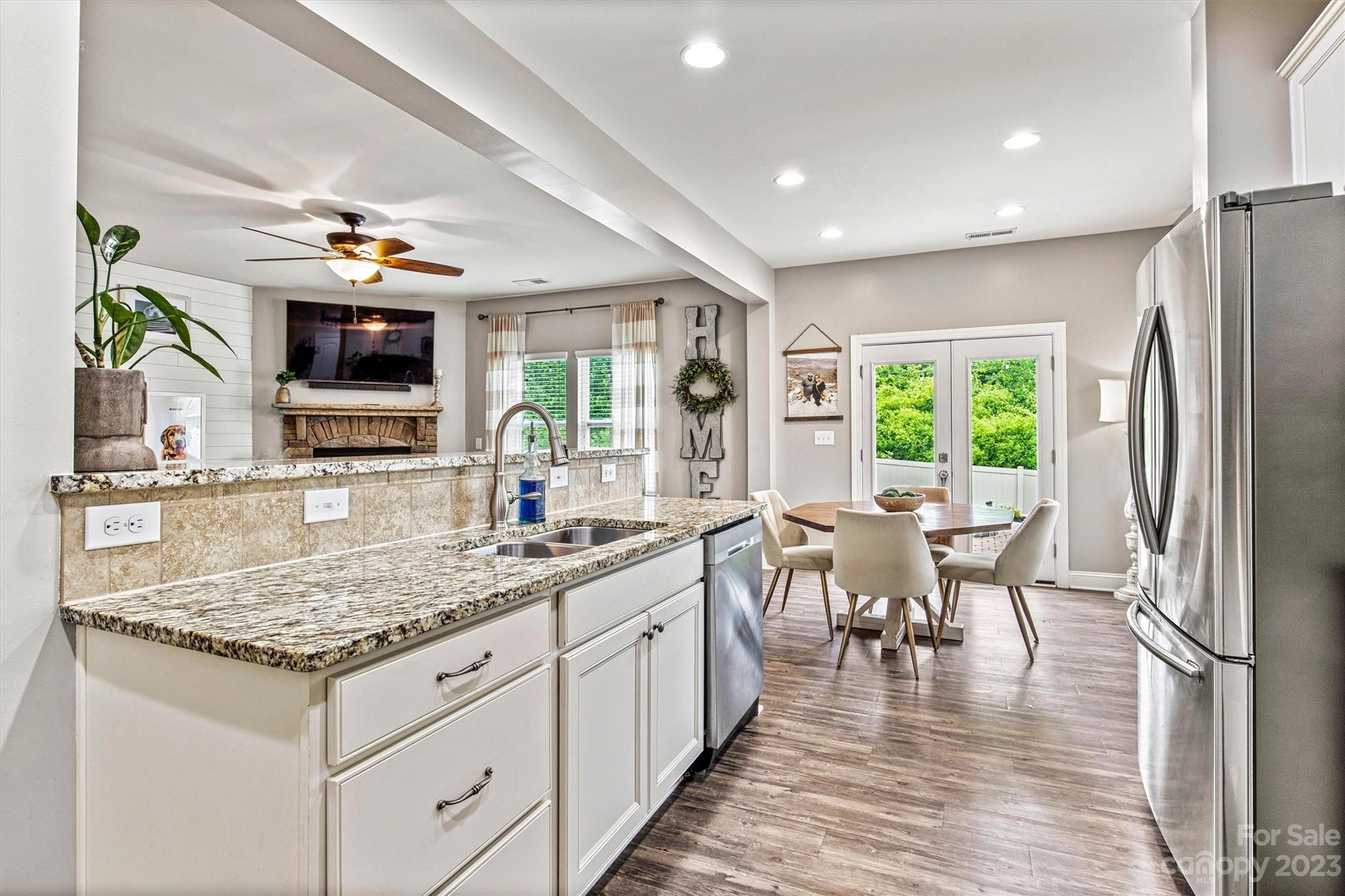 6054 Durango Way Denver, NC 28037 - Photo 8 of 38 a kitchen with stainless steel appliances granite countertop a stove top oven a sink dishwasher a dining table and chairs with wooden floor
