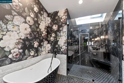 a bathroom with a bathtub a double vanity sink and a large mirror