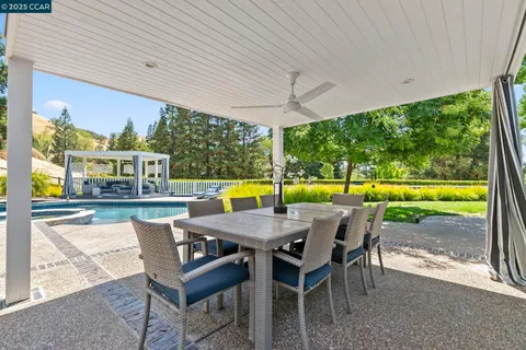 a view of a swimming pool with a patio and a yard