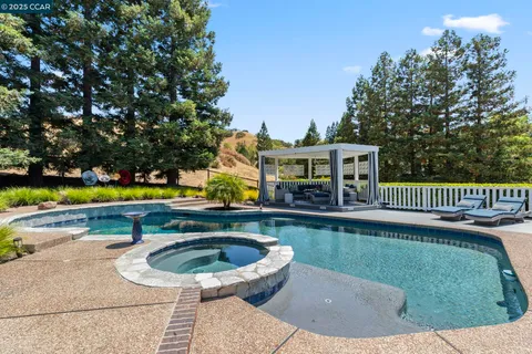 a view of a house with pool and chairs