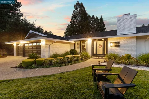 a view of a house with backyard sitting area and garden
