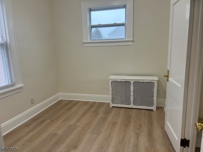 136 Carlton Avenue, Unit 1 East Rutherford, NJ 07073 - Photo 11 of 16 a view of an empty room with wooden floor and a window