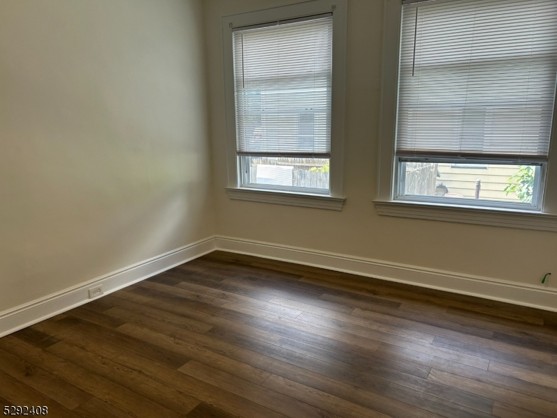 136 Carlton Avenue, Unit 1 East Rutherford, NJ 07073 - Photo 6 of 16 an empty room with wooden floor and windows