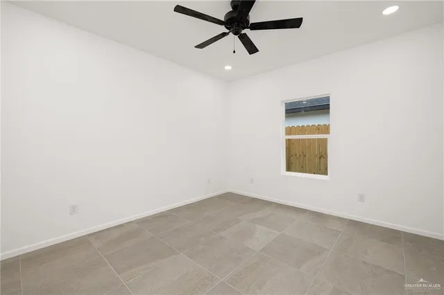 an empty room with a ceiling fan and a window