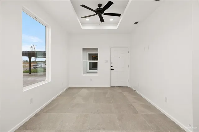 an empty room with windows and fan