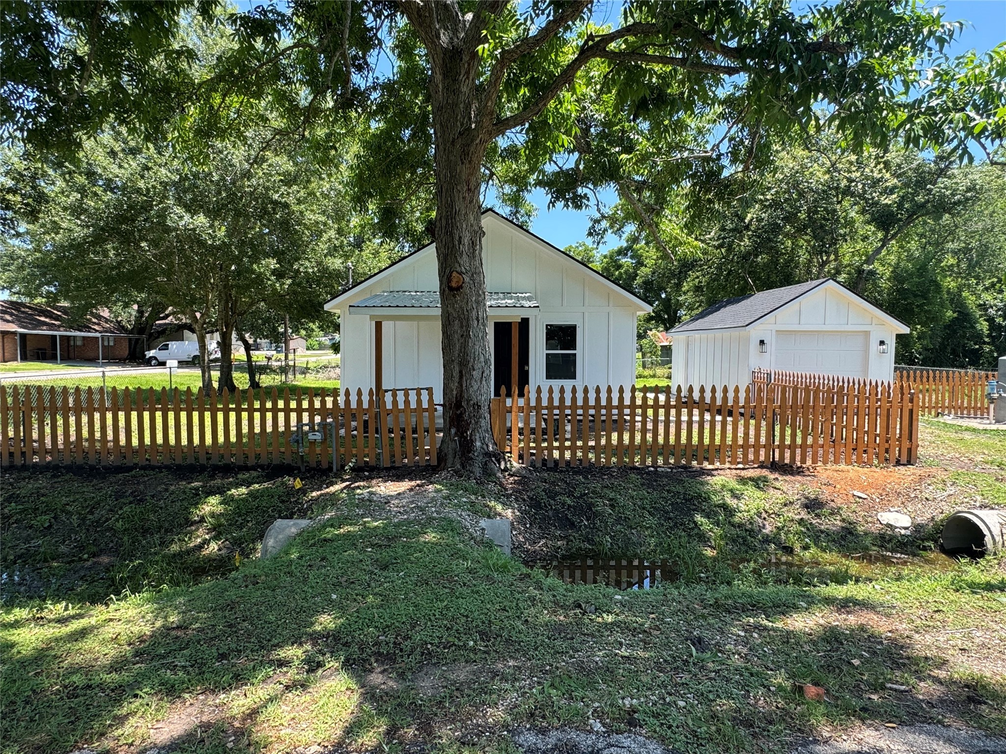 a view of a house with a small yard and a wooden deck