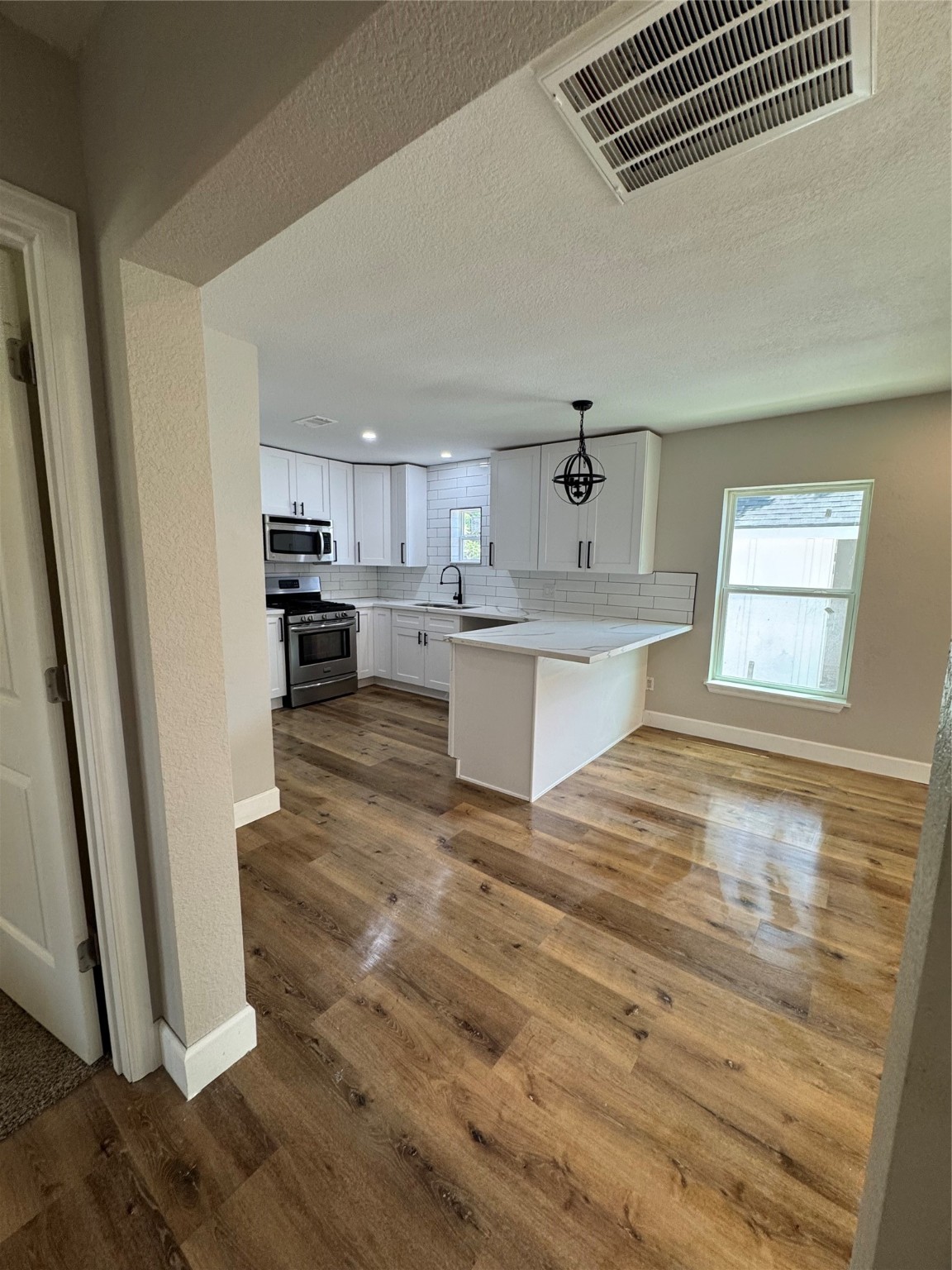 4301 Peck Avenue Santa Fe, TX 77517 - Photo 3 of 8 a large kitchen with cabinets and wooden floor