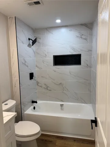 a bathroom with a toilet and a bathtub