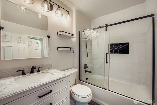a bathroom with a granite countertop sink toilet and shower