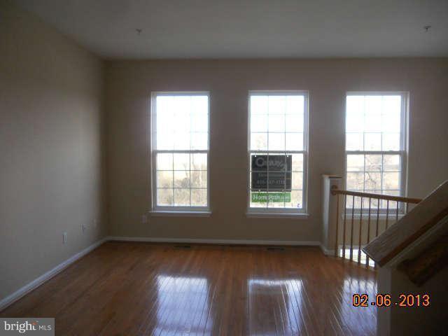 636 Luthardt Road Baltimore, MD 21220 - Photo 2 of 11 an empty room with wooden floor and windows