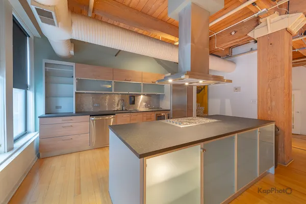 a kitchen with stainless steel appliances granite countertop a sink and a refrigerator