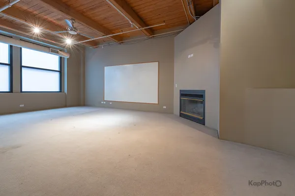a view of an empty room with a fireplace and a window