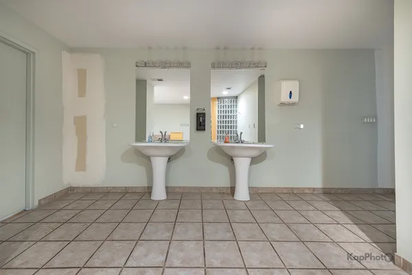 a view of empty room with a sink and a mirror