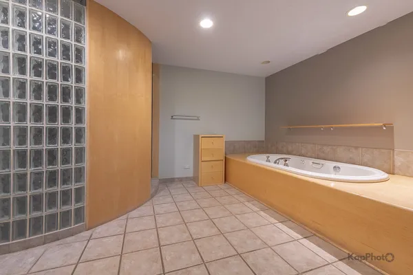 a spacious bathroom with a tub shower and a sink