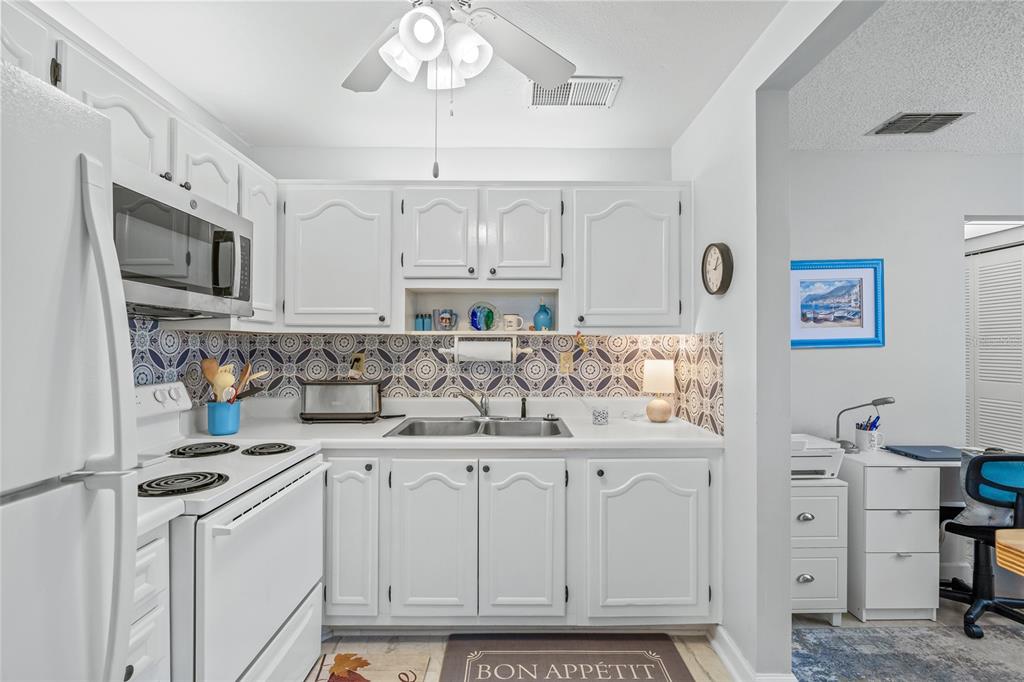 11923 Boynton Lane, Unit B New Port Richey, FL 34654 - Photo 13 of 34 a kitchen with granite countertop a sink cabinets and stainless steel appliances