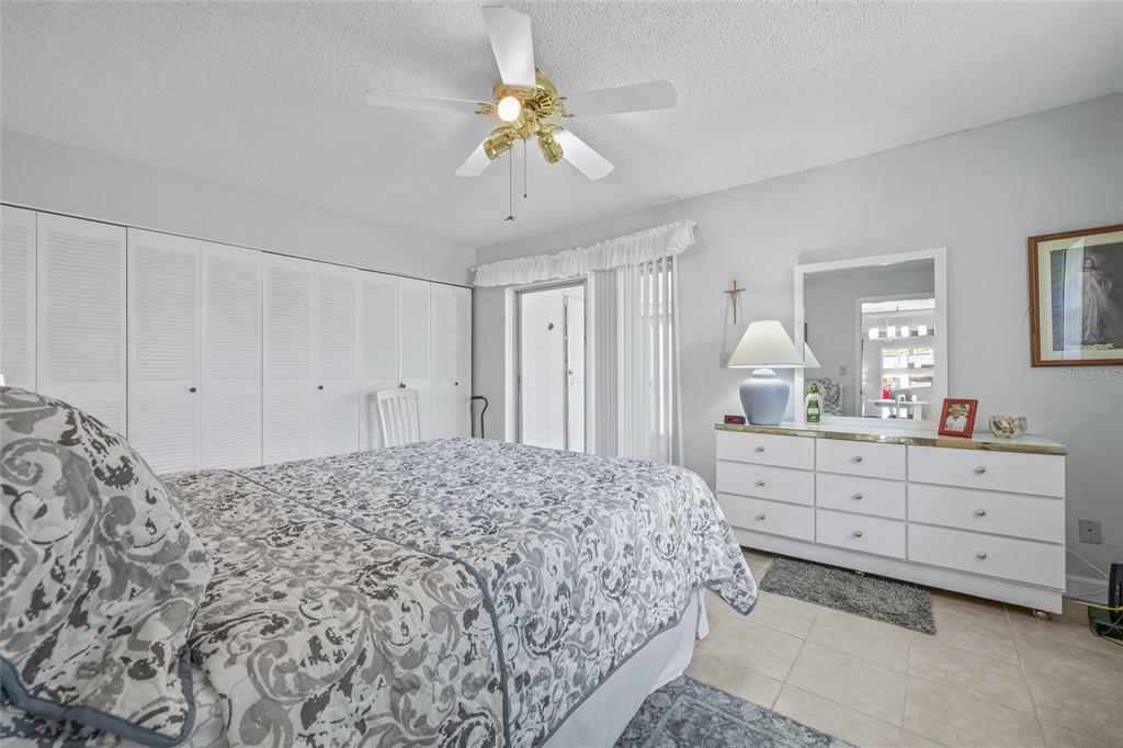 11923 Boynton Lane, Unit B New Port Richey, FL 34654 - Photo 17 of 34 a bedroom with a bed and a chandelier