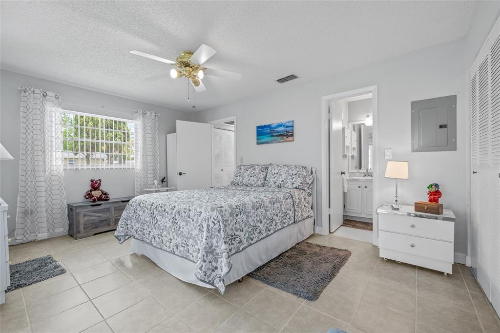 11923 Boynton Lane, Unit B New Port Richey, FL 34654 - Photo 19 of 34 a bedroom with a bed and a chandelier
