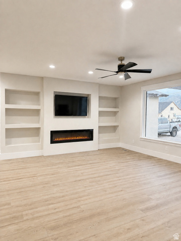 840 South Jones Road Monroe, UT 84754 - Photo 2 of 6 Built-in shelving, integrated electric fireplace, LVP flooring, recessed lighting, and a modern ceiling fan