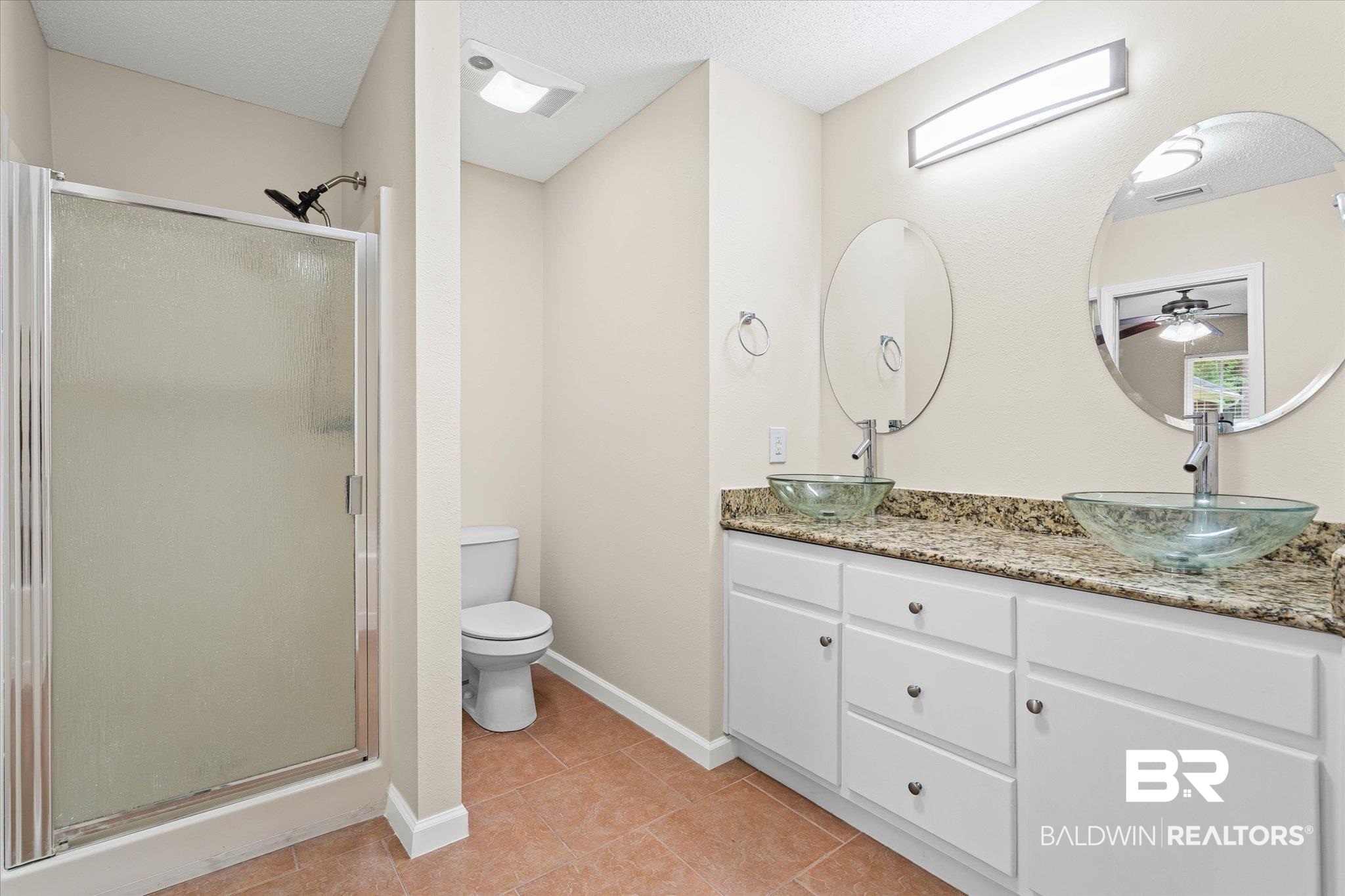 157 Bay View Drive Daphne, AL 36526 - Photo 10 of 22 Full bathroom featuring a stall shower, double vanity, light tile patterned flooring, and a textured ceiling