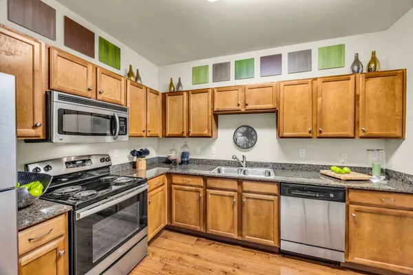 a kitchen with stainless steel appliances granite countertop a sink stove and cabinets