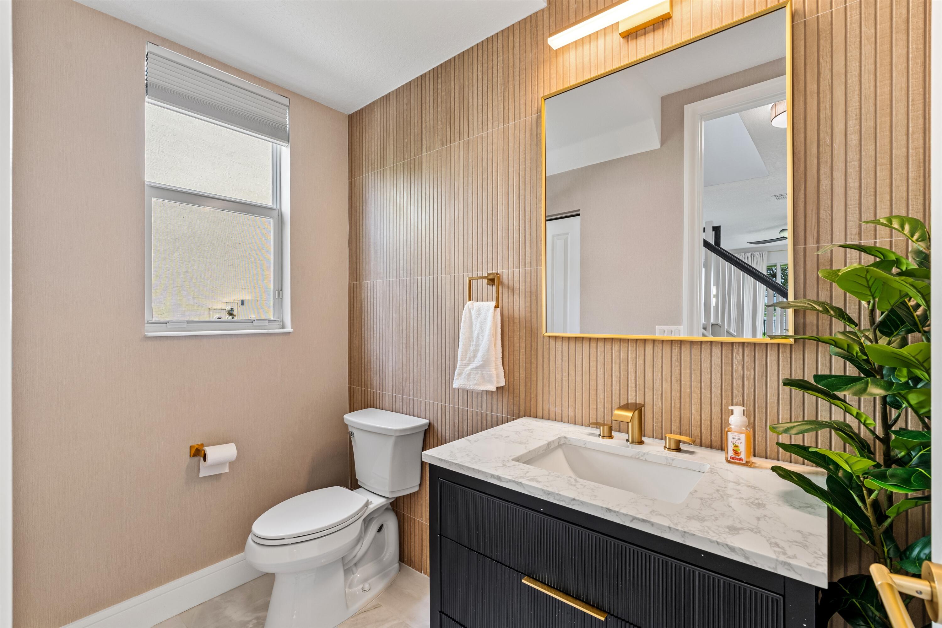 1570 Northwest 48th Place Boca Raton, FL 33431 - Photo 13 of 30 a bathroom with a sink a toilet and a mirror