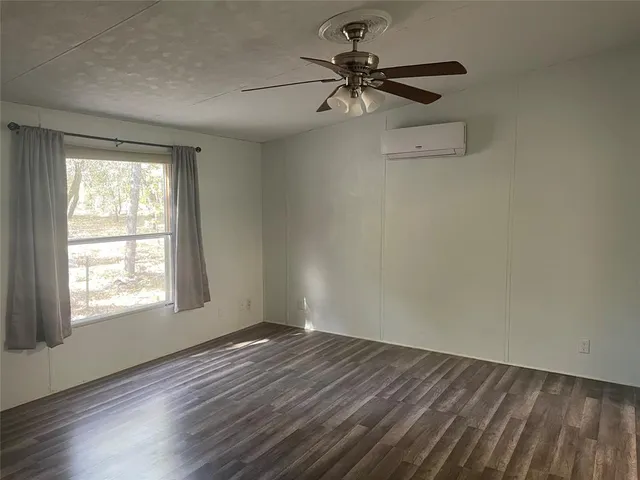 an empty room with a window and a fan