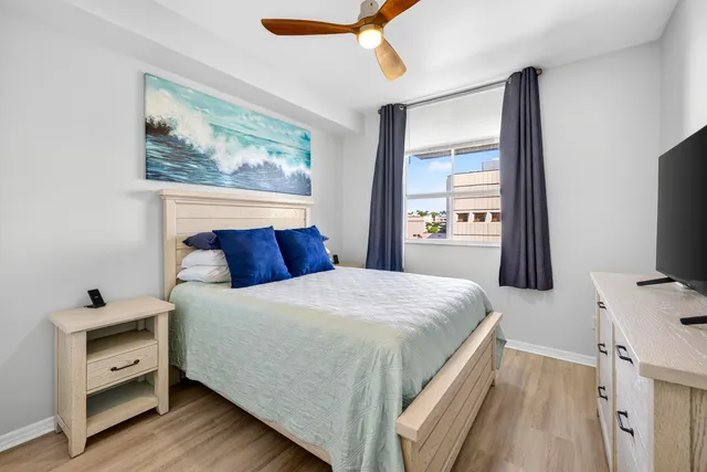 a bedroom with a bed and a flat tv screen on dresser