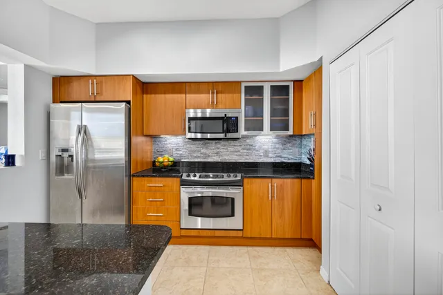 a kitchen with stainless steel appliances granite countertop a refrigerator and a sink
