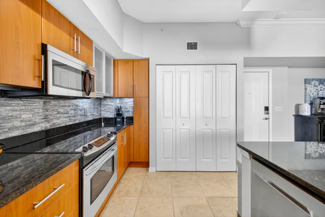a kitchen with stainless steel appliances granite countertop a stove a sink and a microwave