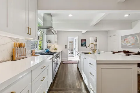 a large white kitchen with cabinets