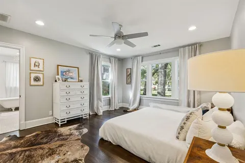 a spacious bedroom with a bed and wooden floor