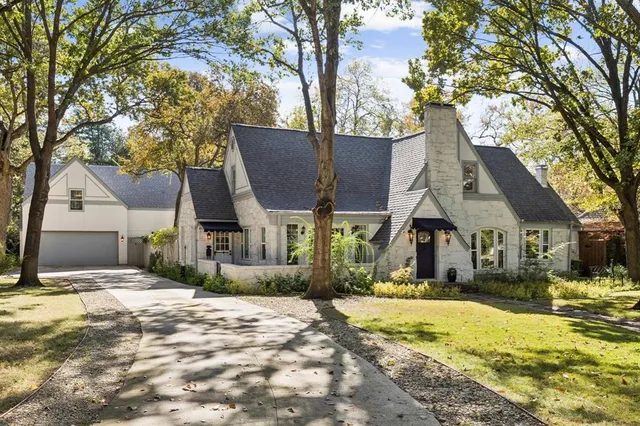 a front view of house with yard and trees around