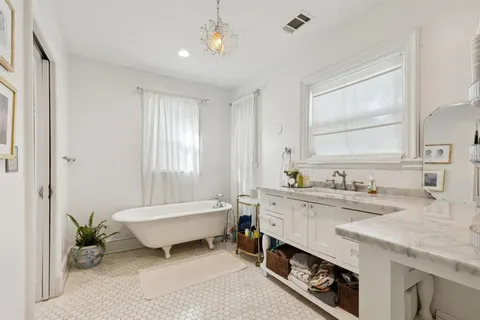 a spacious bathroom with a granite countertop sink mirror and a bathtub