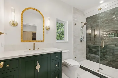 a bathroom with a double vanity sink toilet and shower