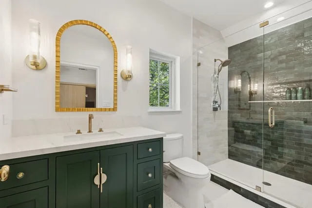 a bathroom with a double vanity sink toilet and shower
