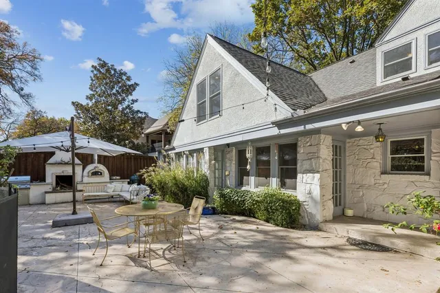 a view of a white house with a yard and potted plants