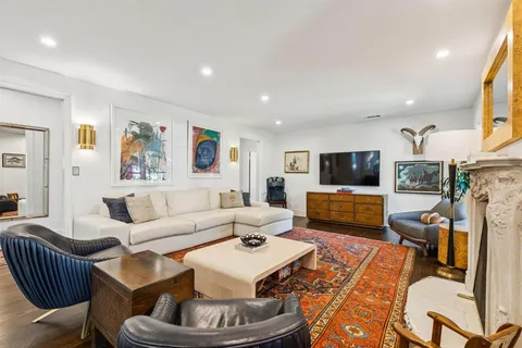 a living room with furniture kitchen view and a flat screen tv