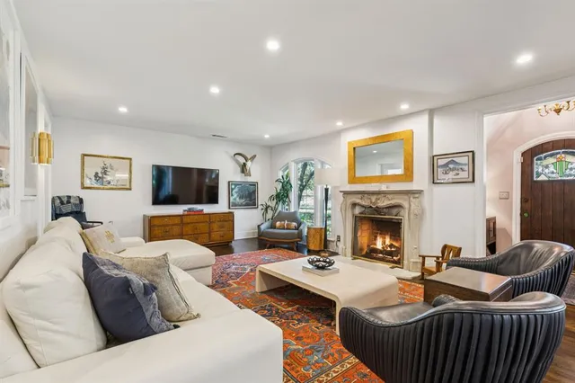 a living room with furniture a fireplace and a flat screen tv