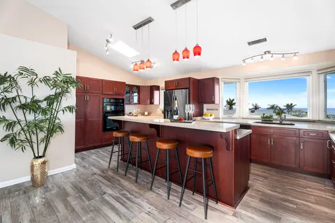 a kitchen with granite countertop a sink cabinets and wooden floor
