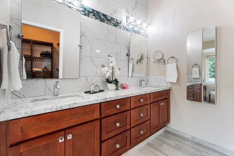 a bathroom with double vanity and a mirror