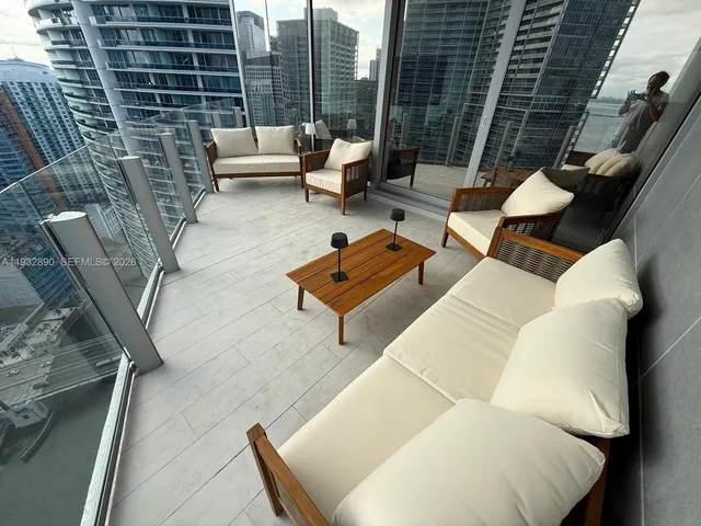 a living room with furniture and a floor to ceiling window