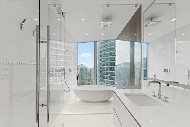 a bathroom with a large tub a sink a window and a shower